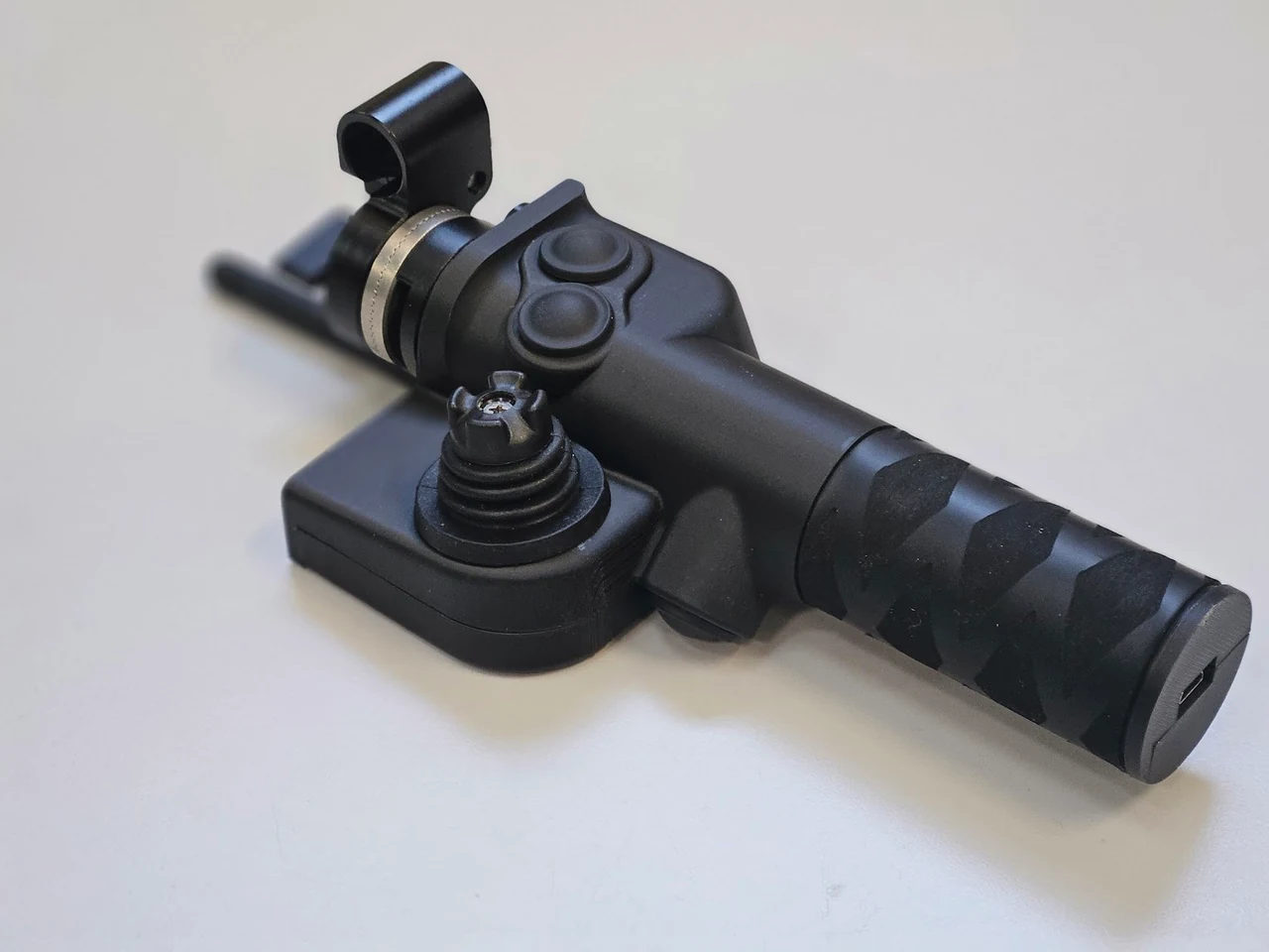 Gros plan sur une poignée noire de la VCam avec son joystick et ses boutons