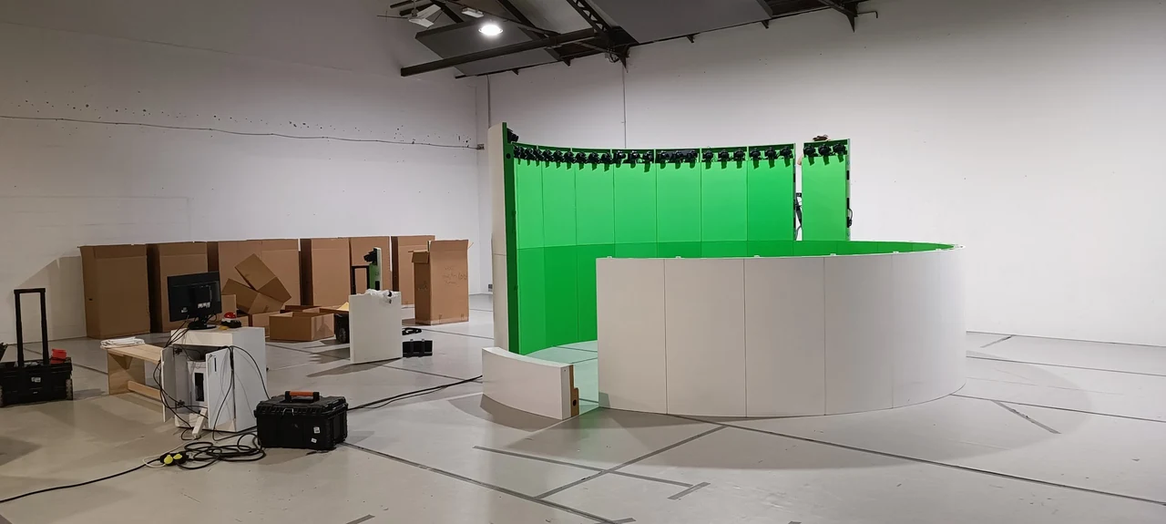 Studio à fond vert incurvé et comptoir blanc, installés dans un grand hall lumineux