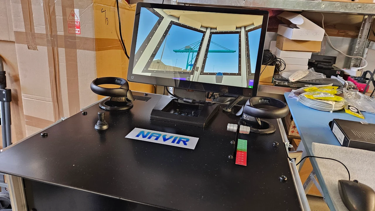 Poste de simulation NAVIR sur une table noire : écrans, volants, joysticks et plaque NAVIR