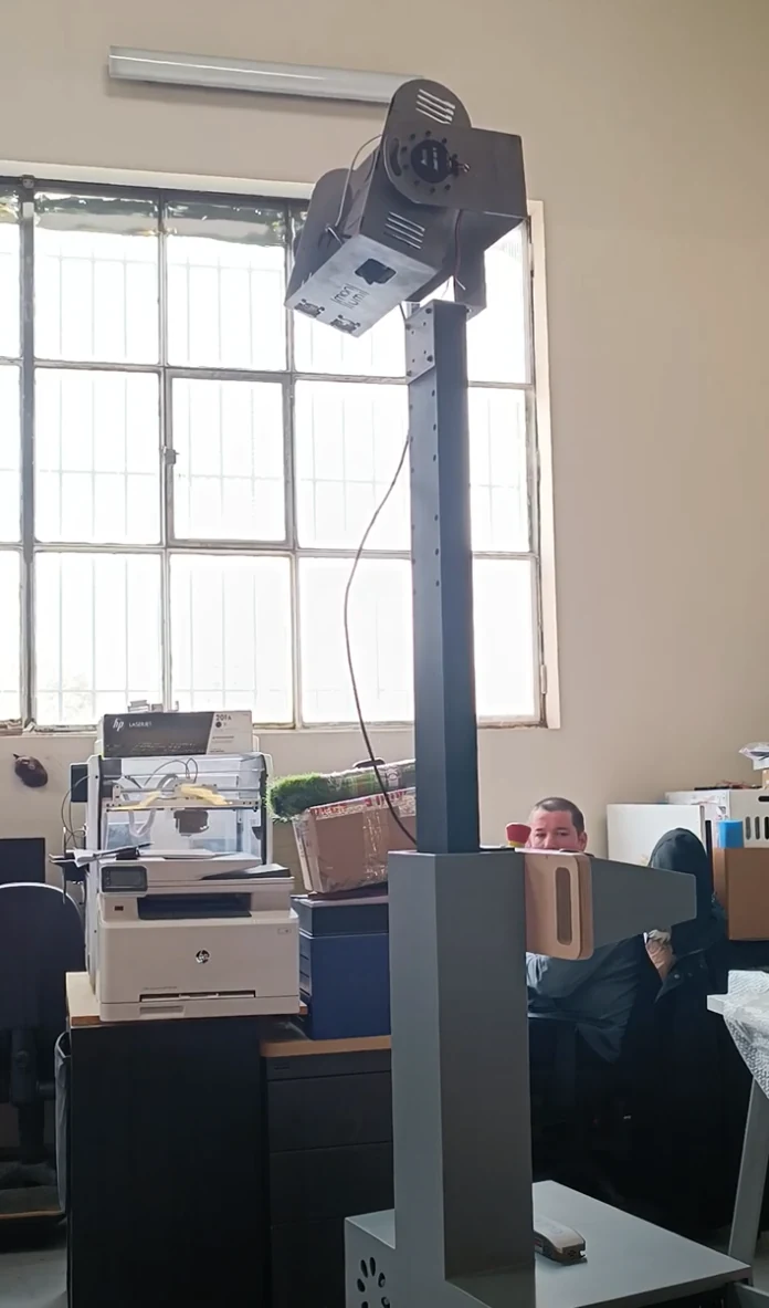 Colonne Wally verticale surmontée de sa tête de projection orientable, dans un atelier avec grandes fenêtres