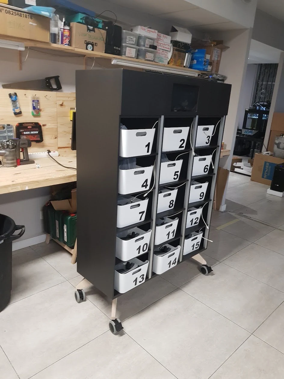 Meuble noir sur roulettes à casiers numérotés pour le rangement des casques, dans un atelier