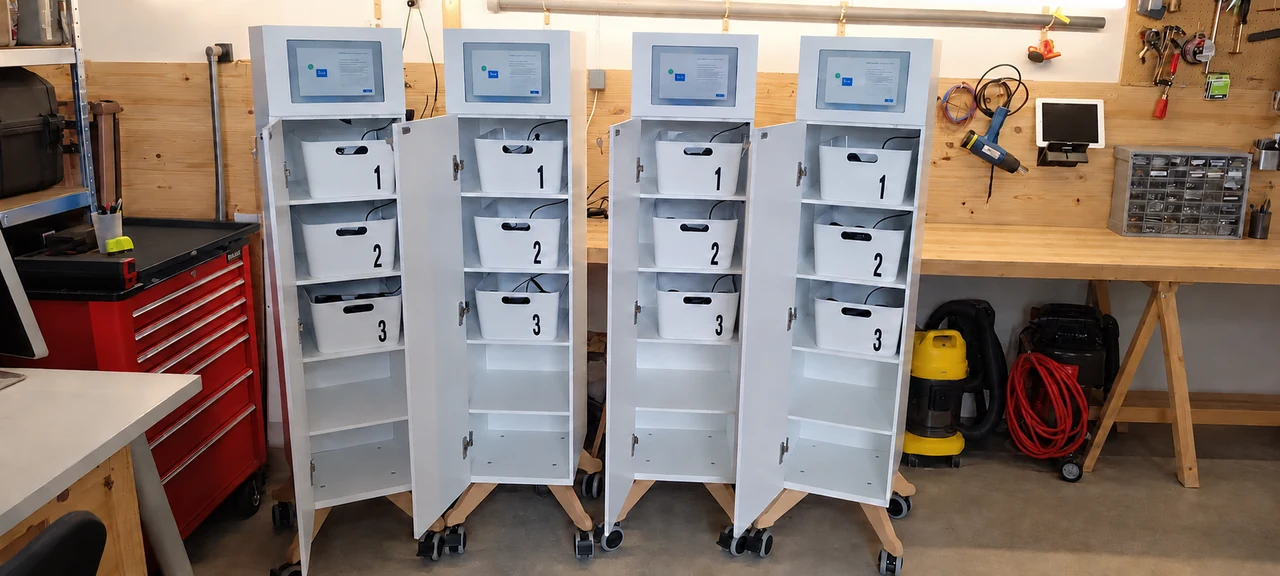 Quatre meubles blancs Jukebox VR à tiroirs de rangement pour casques, alignés dans un atelier ordonné