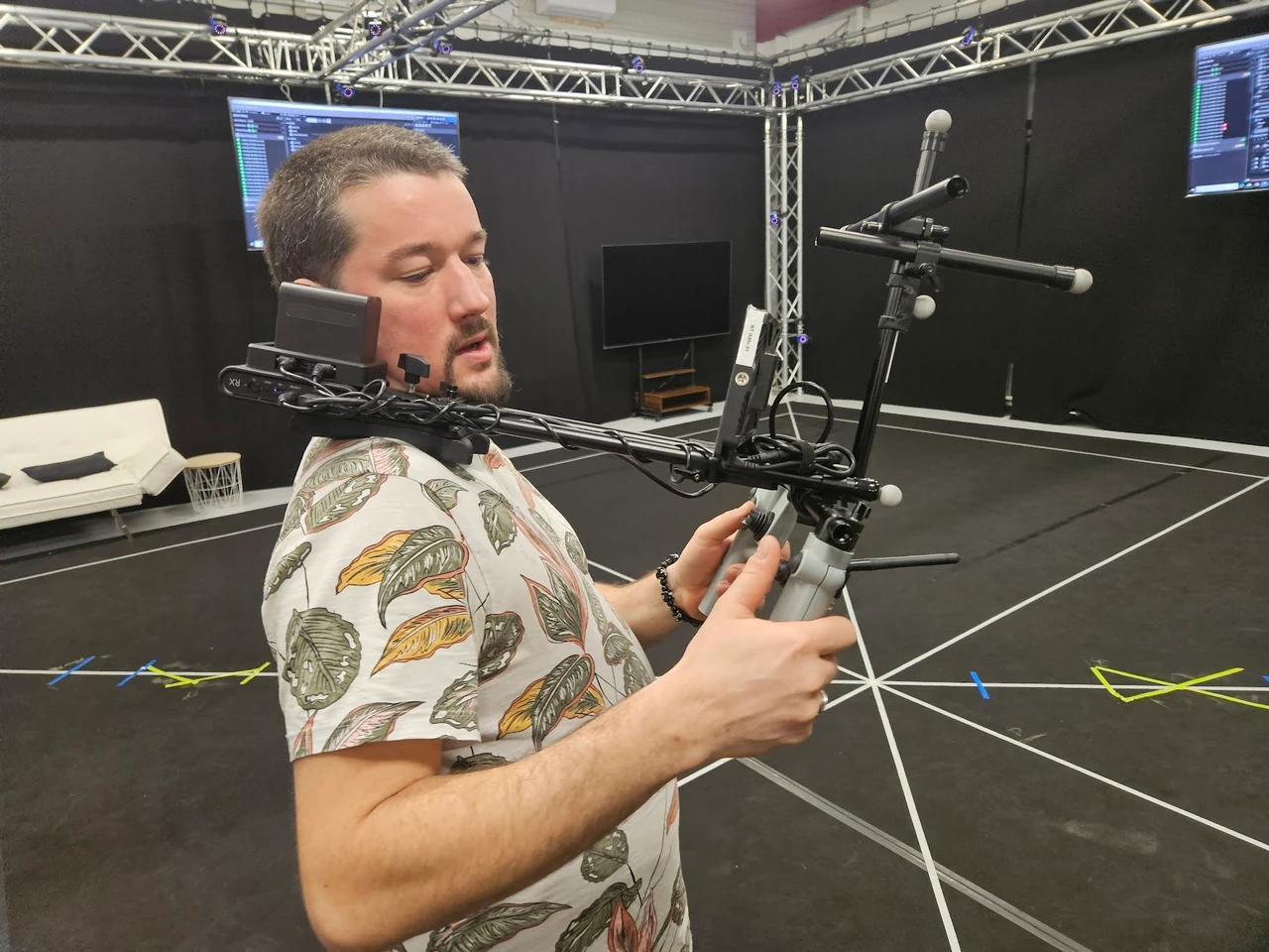 Opérateur tenant la VCam par ses deux poignées dans un studio de motion capture.