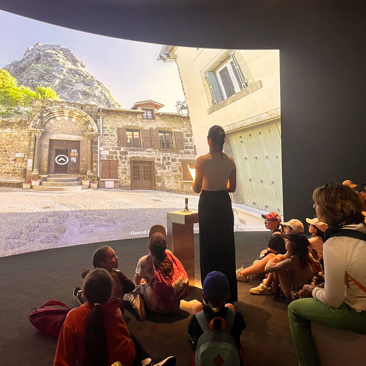 Groupe de visiteurs devant la projection de la visite virtuelle de Saint-Michel d’Aiguilhe.